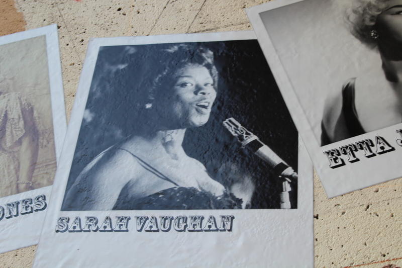 Black-and-white photo of Sarah Vaughan singing at a microphone, displayed on the music mural.