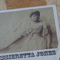  Sepia-toned historical photo of Sissieretta Jones in formal dress, displayed on the music mural.