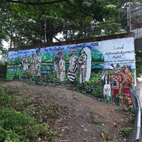 Full view of Land Acknowledgement Mural showing the Pan-Indian Movement 1920 with named Indigenous figures painted on mural wall.