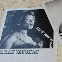 Black-and-white photo of Sarah Vaughan singing at a microphone, displayed on the music mural.